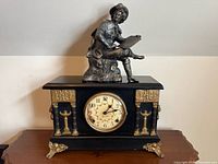 Front view of clock with figurine on top