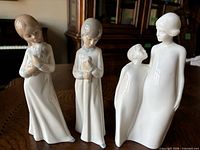 All three porcelain figurines standing on table
