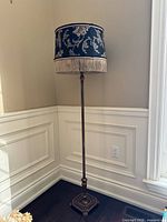 Full view of floor lamp in corner showing entire height, pole and base