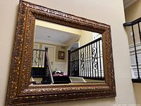 Front view of mirror showing gold ornate frame and reflection