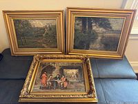Group shot of three framed paintings on sofa