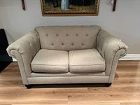 Front view of beige tufted loveseat