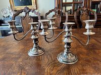 Front view of both three-light candle holders on table