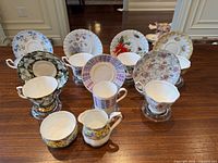 Full set of teacups, saucers, creamer, sugar displayed on table
