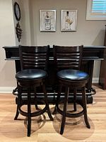 front view of both wooden bar stools showing seats, backs, and leg structure