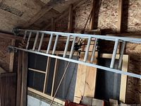 Full view of ladder stored horizontally in garage rafters