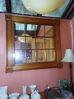 Full view of wood-framed nine-pane mirror on wall