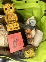 Overview of basket with multiple owl figurines and trinkets