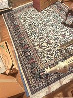 Full view of patterned area rug showing design, colors, and fringe