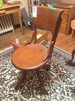 Front angled view of oak swivel chair showing overall design and grain