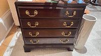 Front view of Ethan Allen 4-drawer chest showing drawers, brass handles, bracket feet