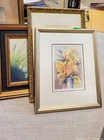 Two framed floral watercolors plus third ornate frame visible