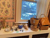 Group shot of ceramics, lamp base, shell, hook, and baskets