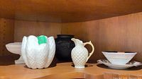 group shot of six porcelain pieces on shelf