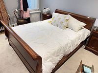 Full view of queen sleigh bed frame with mattress in place