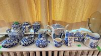 Group view of eight blue and white transferware pieces on shelf
