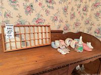Overall lot showing wooden typesetter drawer and array of miniature ceramic shoes, creamers and other small ceramics on dresser