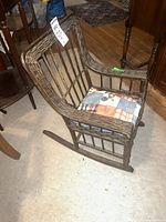 Full view of wicker child’s rocking chair with cushion
