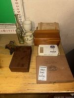 Group shot of boxes, bottle, creamer, carving on table