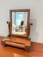 Front view of tilting dresser mirror showing frame, base and drawer