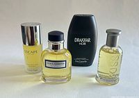Group shot of four eau de toilette bottles: Escape, Dolce & Gabbana, Drakkar Noir, Boss