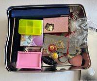 overview of tin with boxes, organizer, keychain, bracelets, stone, heart