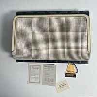 clutch purse on presentation box with papers