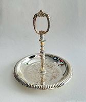 Full view of silver-plated round tray with vertical handle