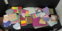 Wide view of mixed stacks of cardstock and scrapbook paper on table