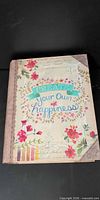 Front cover of floral faux-book box showing design and quote