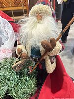 Santa figurine with greenery in red storage bag