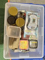 Clear tote with label maker, wood filler tins, plastic box, hardware containers