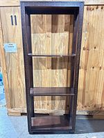 Full front view showing carved trim and four shelves