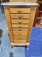 Front view showing eight drawers with metal pulls and cabriole legs
