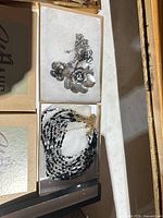 Necklaces in boxes: flower pendant and multi-strand beaded