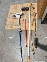 Group shot of all poles, handles, walking sticks and curtain rod on floor