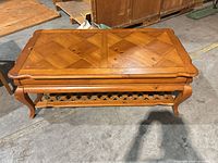 Full view of rectangular veneer coffee table showing parquet top, lower shelf, cabriole legs