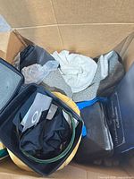 Contents inside cardboard box: Oakley case, sunglasses, pouch, towel, slippers, foam inserts