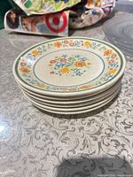 Stack of six floral ceramic dinner plates