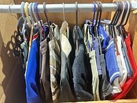 Full lot of tops on hangers showing variety of colors and types