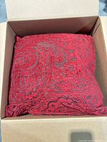 Pillow in shipping box showing fabric color and pattern