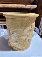 Front view showing embossed bird and foliage design and textured terracotta finish