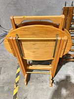 Three folded oval tables stacked in rack