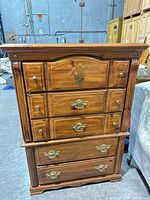 Front view of dresser showing five drawers, floral stencil, brass-tone pulls