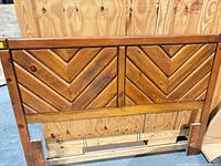 Full front view of solid wood queen headboard showing chevron pattern and leg cut-outs