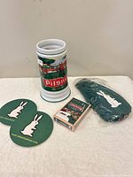 All items grouped: stein, two coasters, deck of cards, sealed bottle cover
