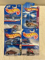 All four Hot Wheels cars on cards