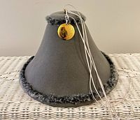 Full view of conical grey felt watchman hat showing medallion and laces
