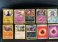 Full spread of ten Pokémon cards in two rows on black surface