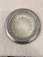 Top view of round ashtray showing glass sunburst base and aluminum rim